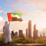 emirati arab man holding uae flag celebrating the national day stockpack adobe stock| وظائف مركز تسهيل وآمر للنساء برواتب مجزية في الامارات