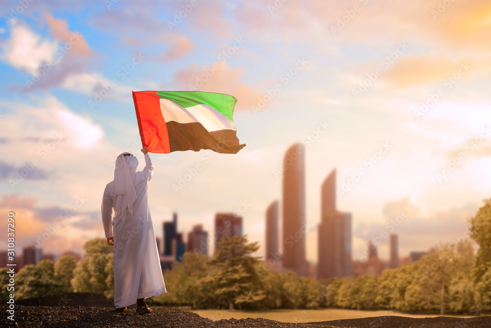emirati arab man holding uae flag celebrating the national day stockpack adobe stock| وظائف مركز تسهيل وآمر للنساء برواتب مجزية في الامارات