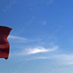 Flag of Qatar rise waving to the wind with sky in the background