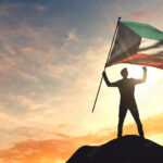 Kuwait flag being waved by a man celebrating success at the top of a mountain. 3D Rendering