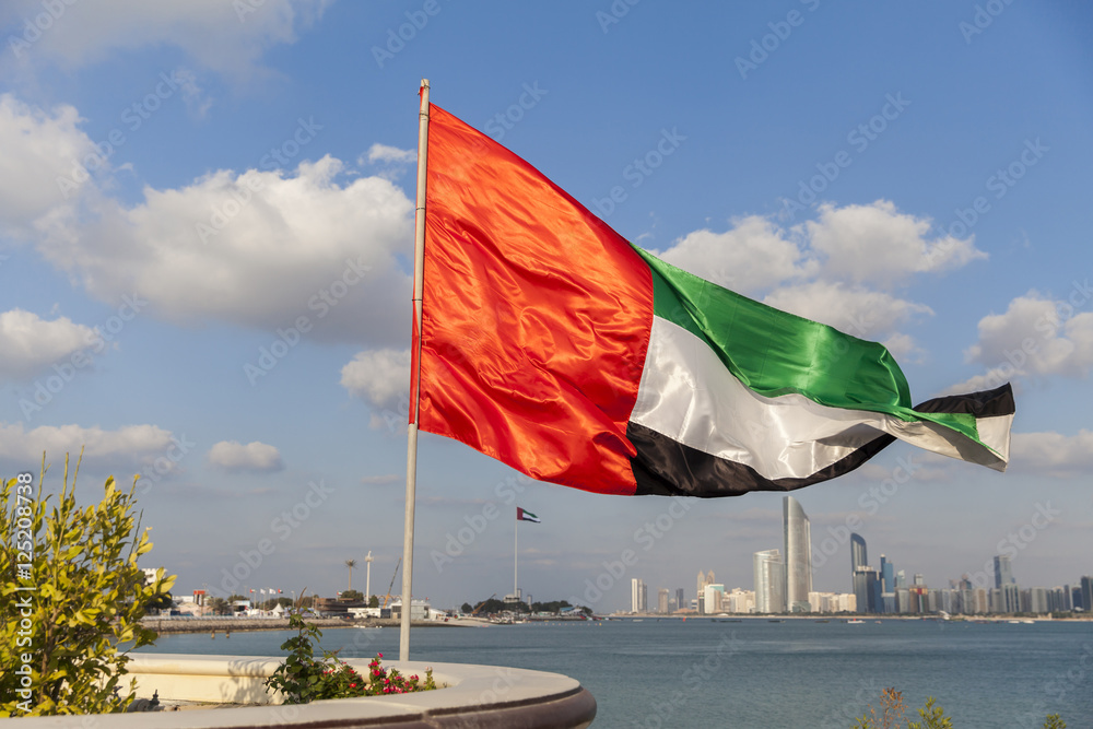 uae flag waving with the background of abu dhabi skyline as part of 43rd national day celebrations stockpack adobe stock| وظائف امن الدولة لجميع التخصصات في الامارات